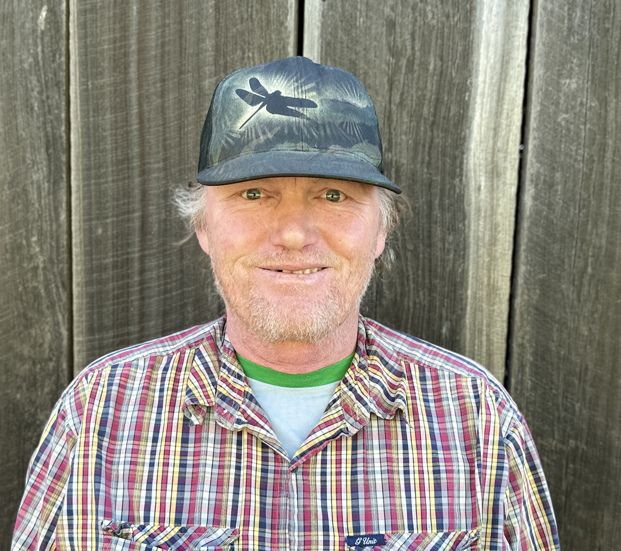 staffmember Kyle Doron poses in front of barn wood