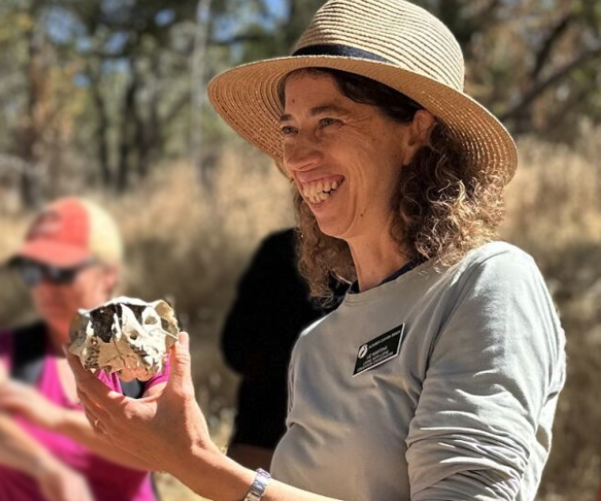 close up of Liz Martins with volunteer trainees and oak trees in background