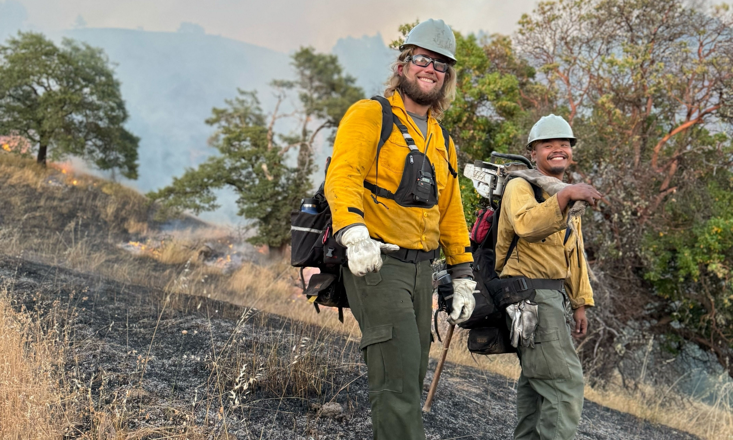 two prescribed fire apprentices walk among an oak woodlands burn unit