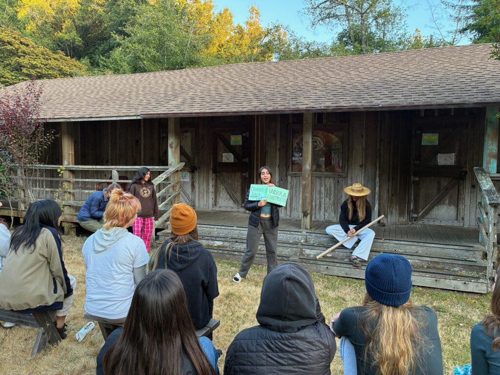 young person presents ideas in front of a group in an outdoor setting
