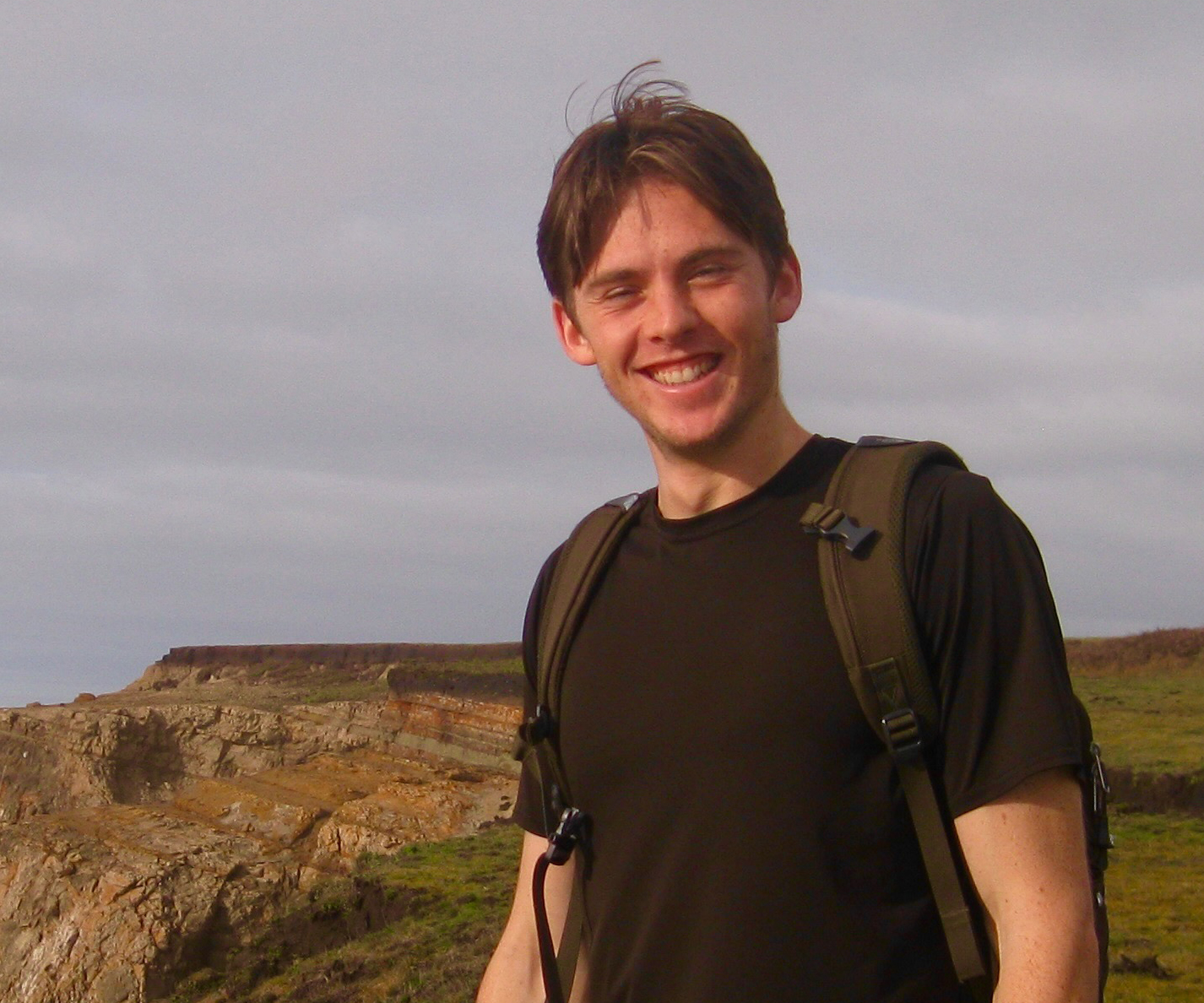 Mid-shot of Josh Harjes standing near the coastline