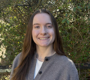 Kira Wates-Williams stands in front of shrubbery