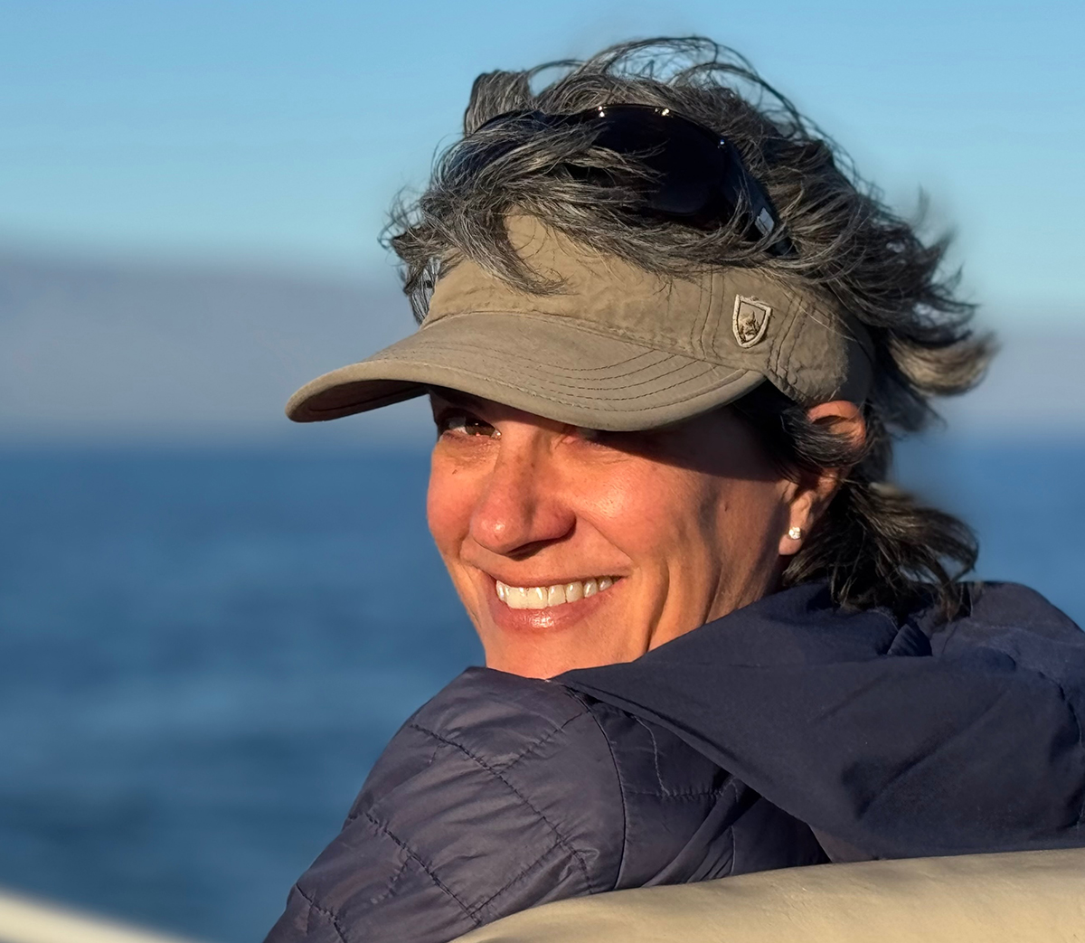 Whitney Mortimer looks at camera from a coastal location